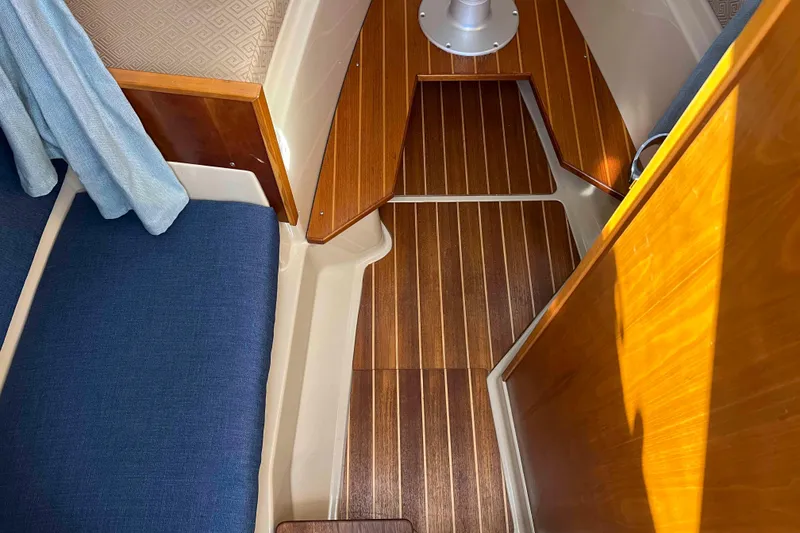 Slide: The Image of Interior of 2012 Cutwater 26 boat with wooden flooring and blue seating. - 32