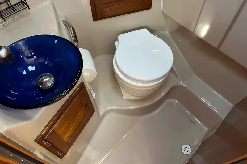 Slide: The Image of 2012 Cutwater 26 boat bathroom with blue glass sink and white toilet. - 35