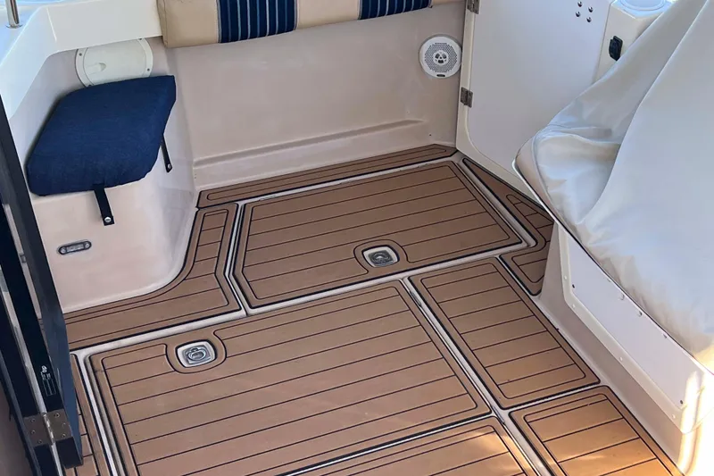 Slide: The Image of 2012 Cutwater 26 boat interior with teak-style flooring and cushioned seating. - 9