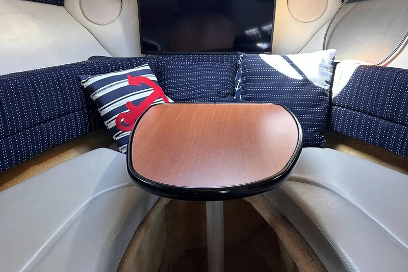 Slide: The Image of Interior of 2006 Crownline 250 CR boat with cozy seating and nautical-themed pillows. - 6