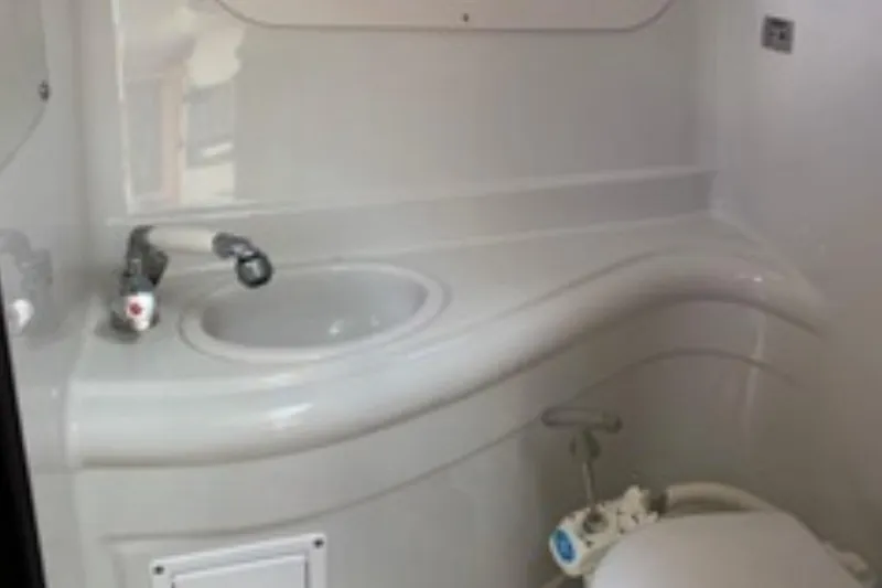 Slide: The Image of 2006 Crownline 250 CR boat bathroom with sink and toilet. - 8