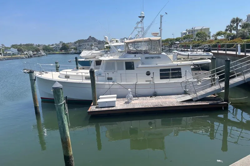 The Image of 1998 Krogen Express 49 yacht docked in a serene marina setting. - 0