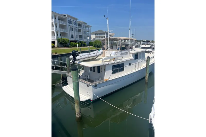 Slide: The Image of 1998 Krogen Express 49 yacht docked near waterfront buildings. - 2