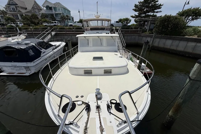 Slide: The Image of 1998 Krogen Express 49 yacht docked in a marina, surrounded by waterfront homes. - 4