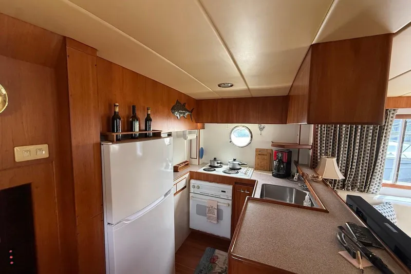 Slide: The Image of Cozy kitchen interior of 1998 Krogen Express 49 yacht with wooden cabinetry and appliances. - 61