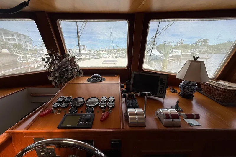 Slide: The Image of Helm of 1998 Krogen Express 49 yacht with navigation instruments and scenic marina view. - 65