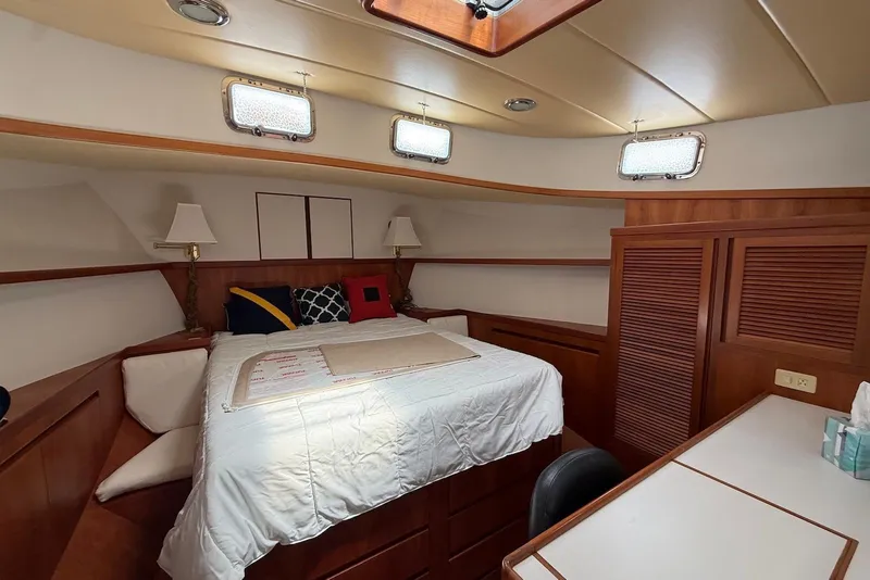 Slide: The Image of Cozy cabin interior of 1998 Krogen Express 49 yacht with bed, lamps, and wooden cabinetry. - 67