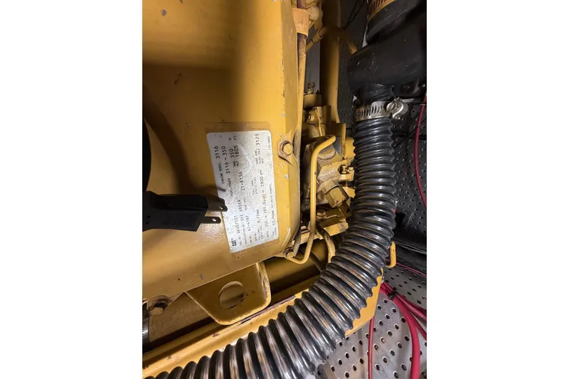 Slide: The Image of Engine compartment of 1998 Krogen Express 49 with visible label and coiled hose. - 79