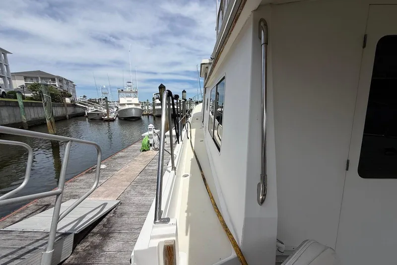 Slide: The Image of 1998 Krogen Express 49 yacht docked at marina, side view with clear sky. - 9