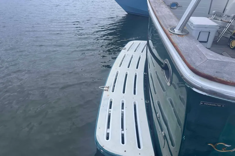 Slide: The Image of Interior of 1998 Krogen Express 49 with teal sofa, wooden table, and nautical decor. - 19