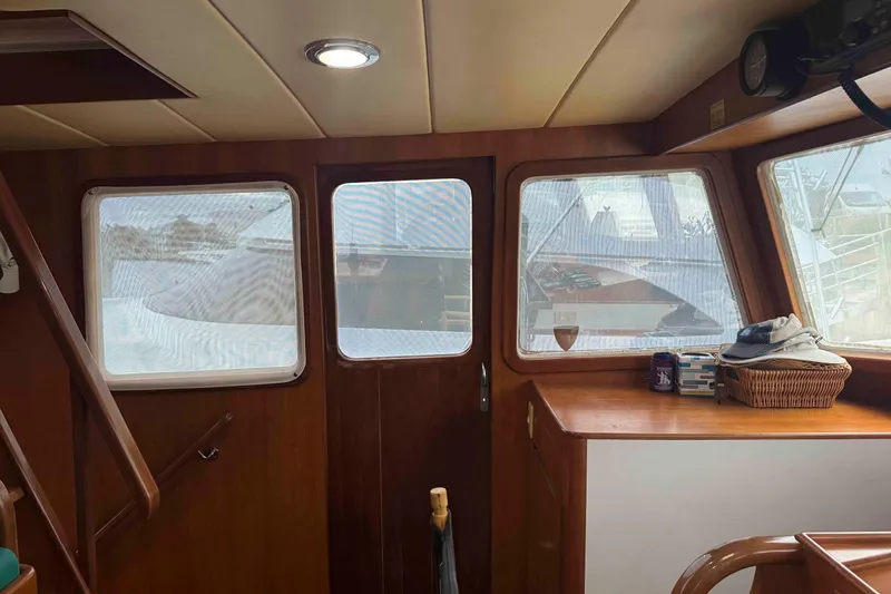 Slide: The Image of 1998 Krogen Express 49 yacht kitchen with wooden cabinetry, stove, and cozy seating area. - 31
