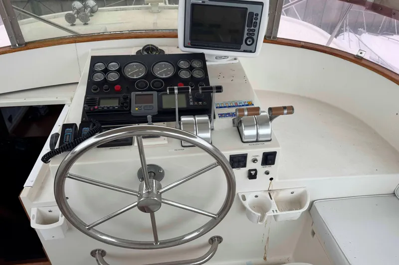 Slide: The Image of Captain's chair and helm of 1998 Krogen Express 49 yacht in marina setting. - 7