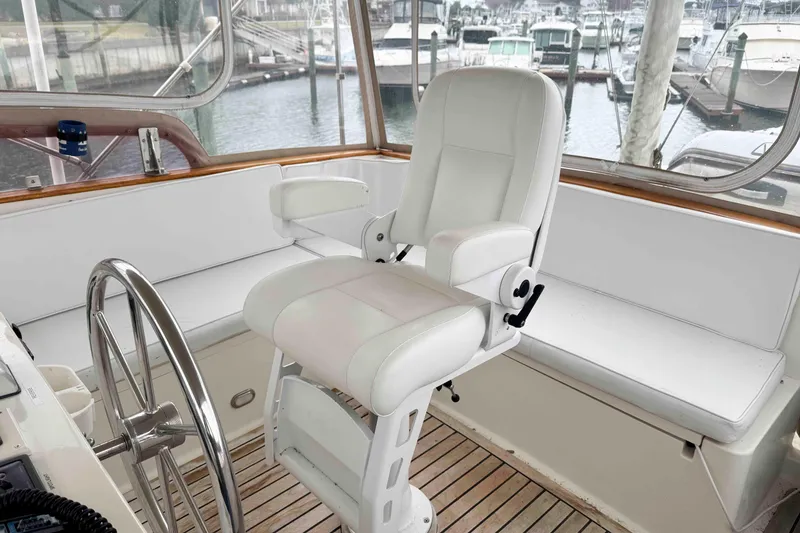 Slide: The Image of Bow view of 1998 Krogen Express 49 docked near coastal homes and parked SUV. - 8