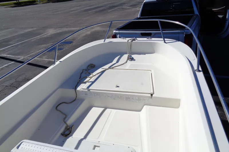 Slide: The Image of 1991 Wahoo 180 boat interior with storage compartment and railing in a parking lot. - 11