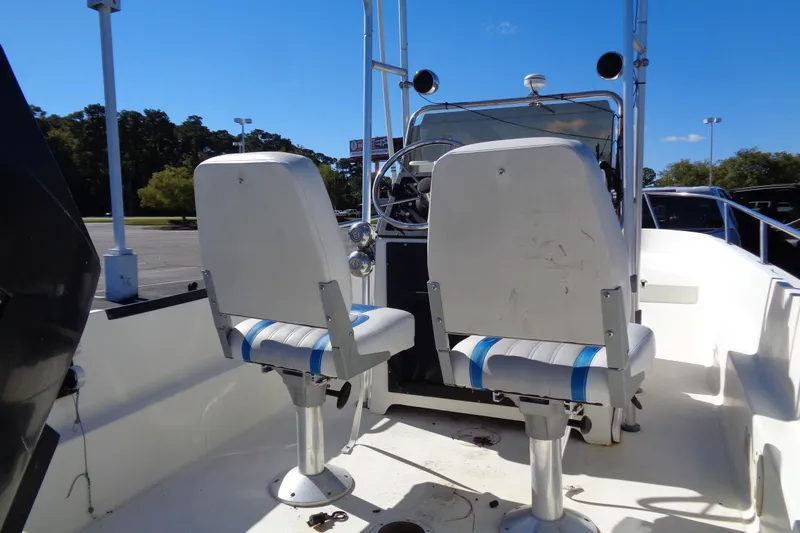 Slide: The Image of 1991 Wahoo 180 boat interior with dual white seats and steering console. - 14