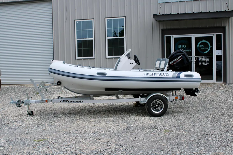 Slide: The Image of 2023 Highfield CL420 inflatable boat on trailer outside a building. - 2