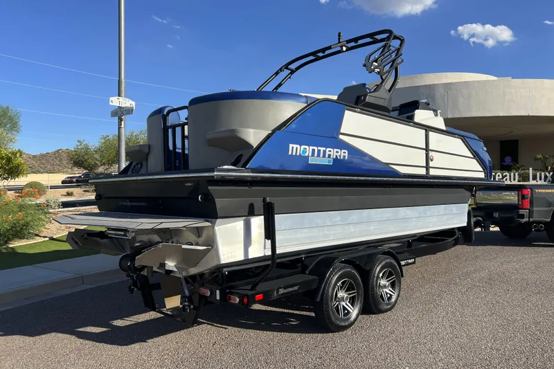 Slide: The Image of 2024 Montara 23 SURF BOSS 2.0 boat on trailer, parked outdoors. - 4