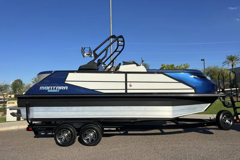 Slide: The Image of 2024 Montara 23 SURF BOSS 2.0 boat on trailer, side view, blue and white design. - 5