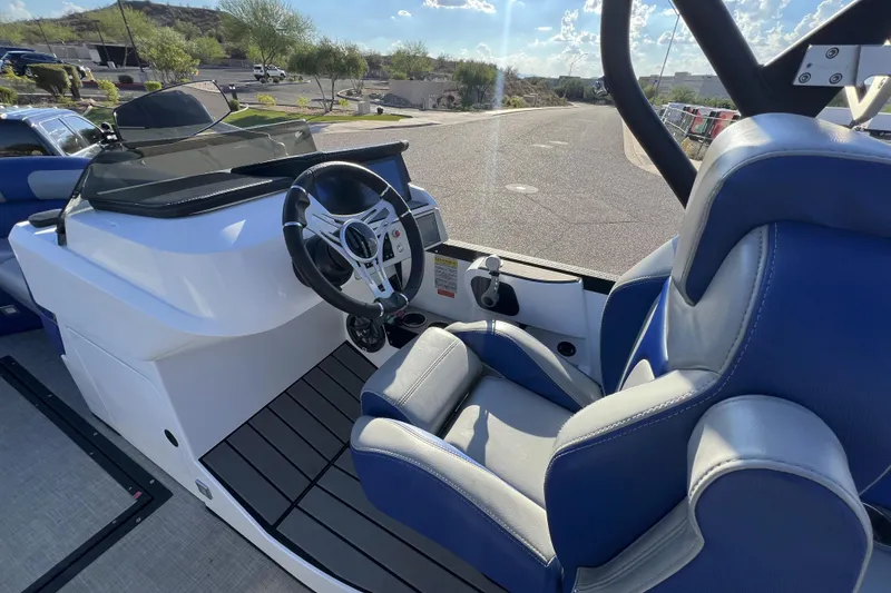 Slide: The Image of 2024 Montara 23 SURF BOSS 2.0 boat interior with steering wheel and blue seating. - 8
