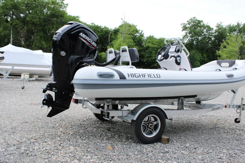 Slide: The Image of 2024 Highfield Sport 460 boat on trailer with Mercury outboard motor, parked outdoors. - 11