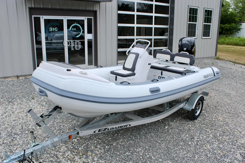 Slide: The Image of 2024 Highfield Sport 460 boat on trailer outside a marine dealership. - 7