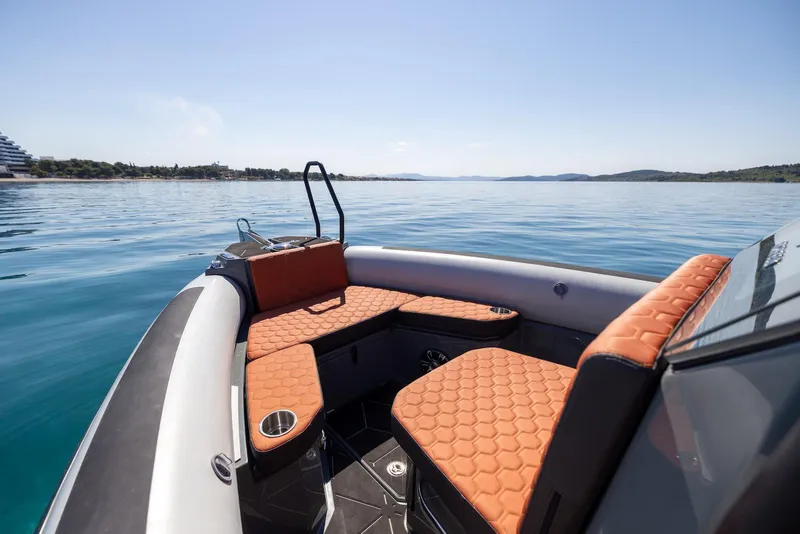 Slide: The Image of Highfield ADV 7 boat interior with orange seating, 2026 model, on calm blue water. - 4