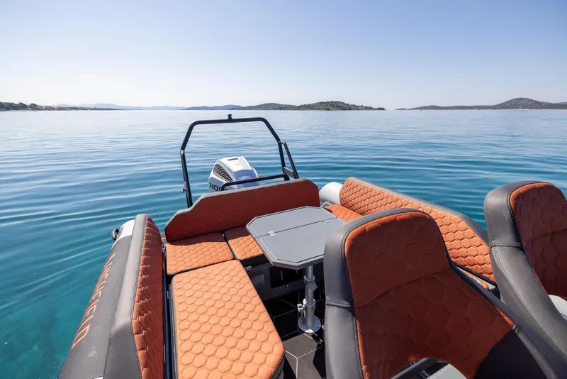 Slide: The Image of 2026 Highfield ADV 7 boat with orange seating on calm blue water. - 6