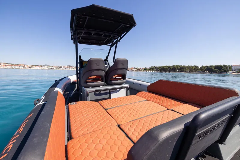 Slide: The Image of 2026 Highfield ADV 7 boat with orange seating, on calm water under clear sky. - 9