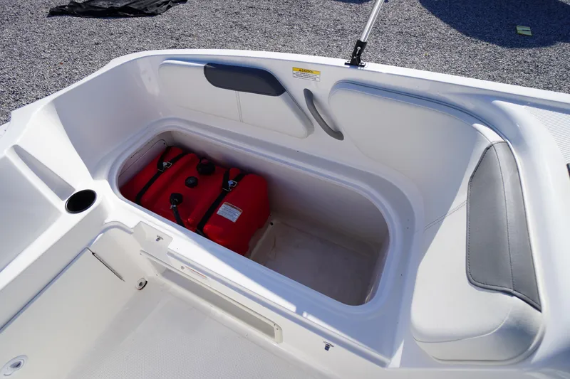 Slide: The Image of 2024 Bayliner Element E18 boat storage compartment with red fuel tanks. - 18