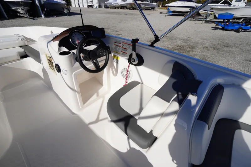 Slide: The Image of 2024 Bayliner Element E18 boat interior with steering wheel and seating area. - 7