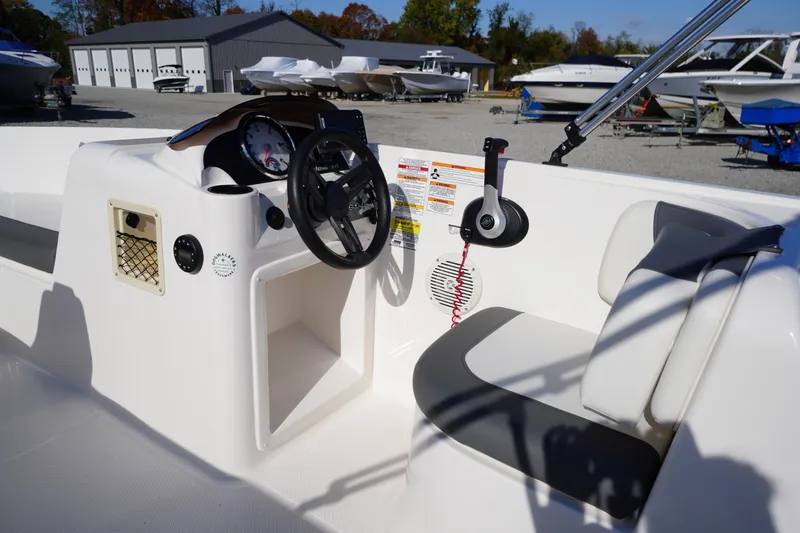 Slide: The Image of 2024 Bayliner Element E18 boat interior with steering wheel and seating. - 8