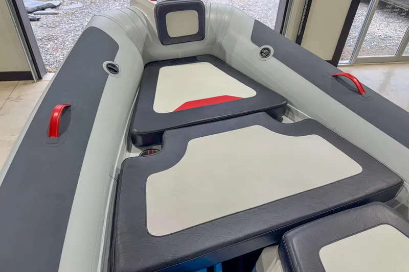 Slide: The Image of 2026 Highfield Velox 560 boat interior with cushioned seating and red handles. - 14