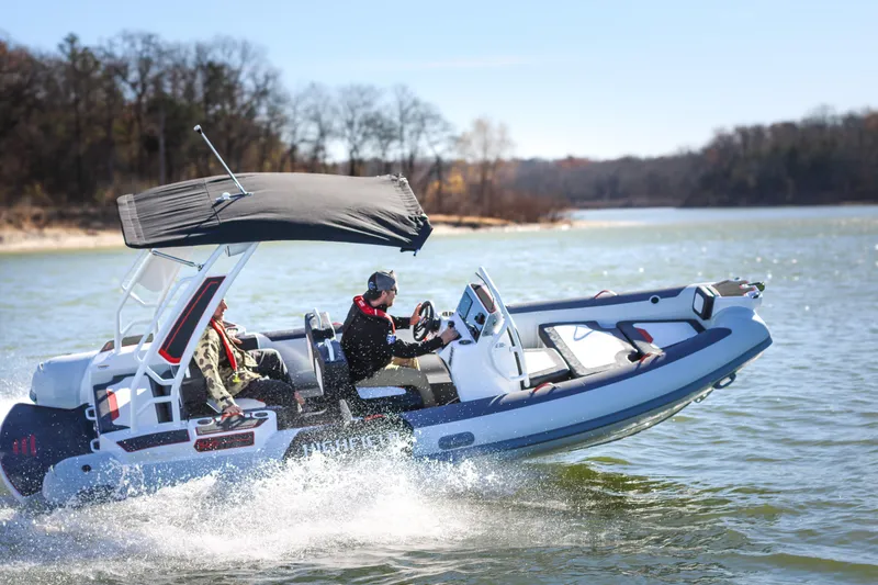 Slide: The Image of 2026 Highfield Velox 560 boat cruising on a sunny lake with passengers. - 21