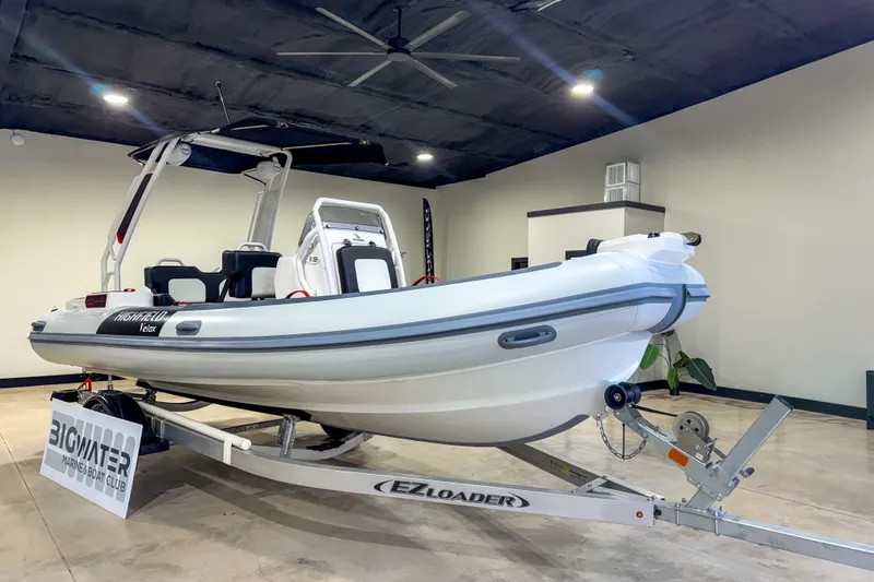 Slide: The Image of 2026 Highfield Velox 560 boat on trailer in showroom, featuring sleek design and modern features. - 6