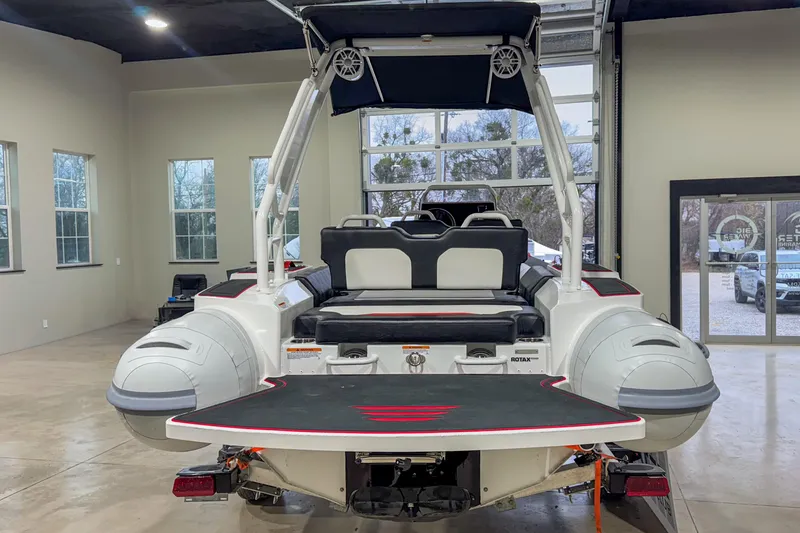 Slide: The Image of 2026 Highfield Velox 560 boat in showroom, rear view with seating and swim platform. - 8