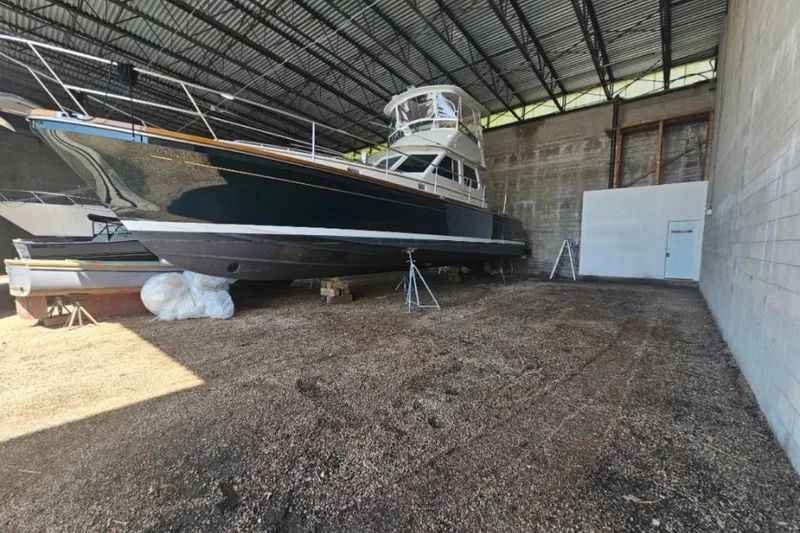 Slide: The Image of 2005 Alden 49 Flybridge Express Cruiser in storage, showcasing sleek design and structure. - 12