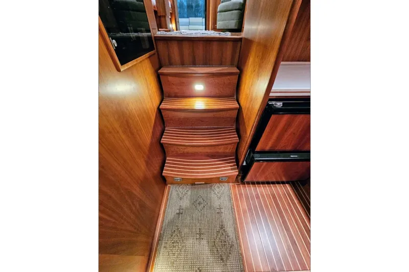 Slide: The Image of Interior of 2005 Alden 49 Flybridge Express Cruiser with wooden stairs and flooring. - 18