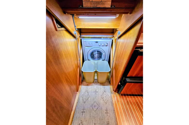 Slide: The Image of Laundry area in 2005 Alden 49 Flybridge Express Cruiser with washer and bins. - 27