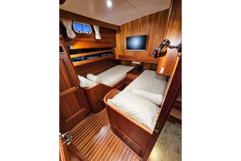 Slide: The Image of Luxurious 2005 Alden 49 Flybridge Express Cruiser cabin with twin beds and wood paneling. - 29