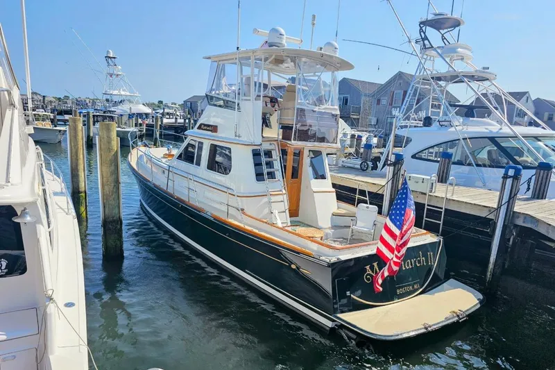 Slide: The Image of 2005 Alden 49 Flybridge Express Cruiser docked in a marina, displaying an American flag. - 4