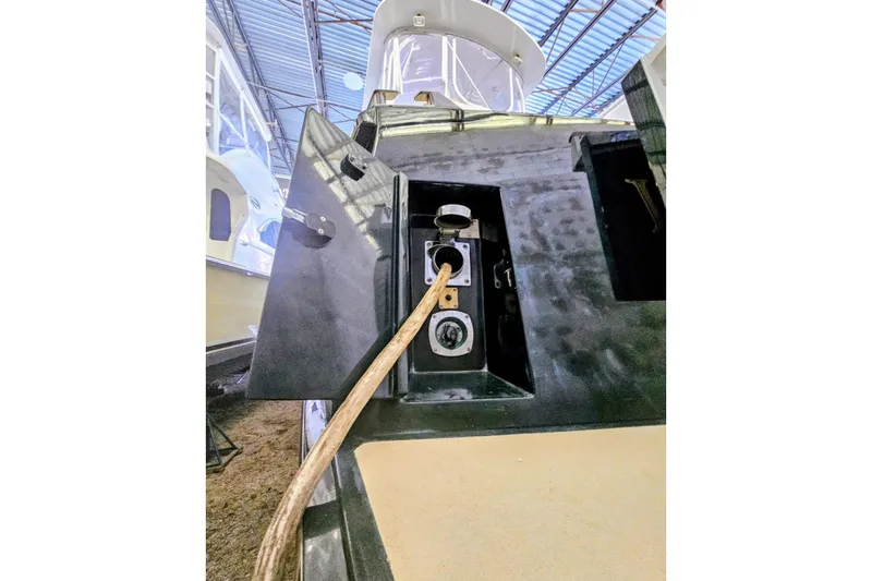 Slide: The Image of Fuel port of 2005 Alden 49 Flybridge Express Cruiser in a covered dock. - 40