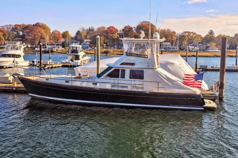 Slide: The Image of 2005 Alden 49 Flybridge Express Cruiser docked in scenic marina setting. - 5