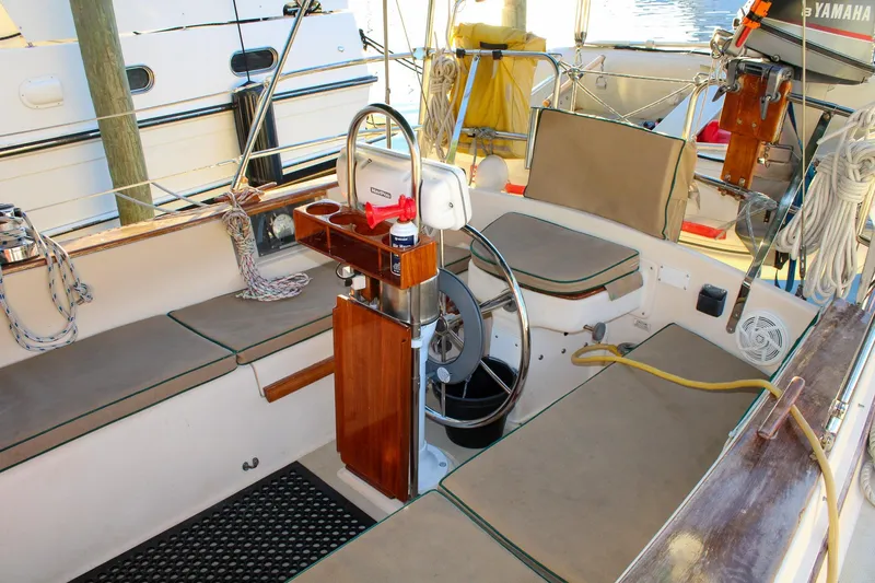 Slide: The Image of 1990 Island Packet 32 sailboat cockpit with seating, steering wheel, and nautical equipment. - 14