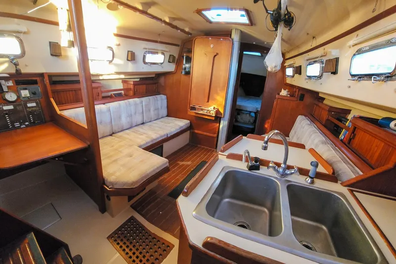 Slide: The Image of Interior of 1990 Island Packet 32 sailboat with cozy seating and kitchen area. - 24