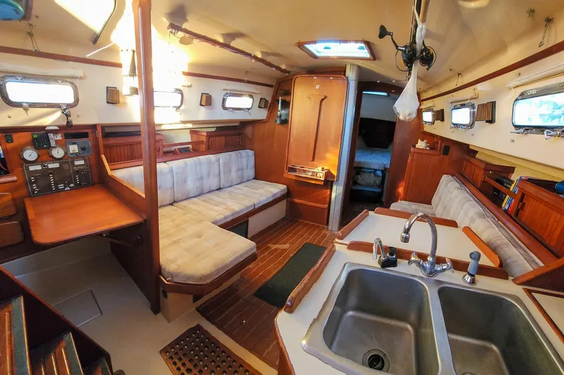 Slide: The Image of Interior of 1990 Island Packet 32 sailboat with cozy seating and kitchen area. - 26