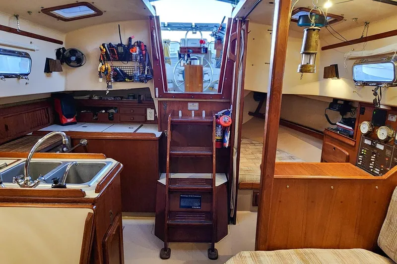 Slide: The Image of Interior of a 1990 Island Packet 32 sailboat, featuring a cozy cabin and kitchen area. - 30
