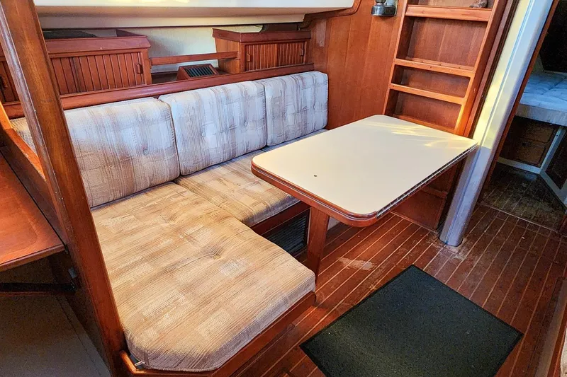 Slide: The Image of 1990 Island Packet 32 interior with cushioned seating and wooden table. - 32