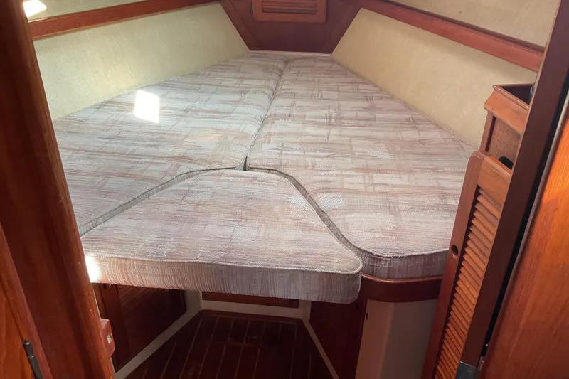 Slide: The Image of 1990 Island Packet 32 sailboat interior with cozy V-berth and wooden accents. - 35