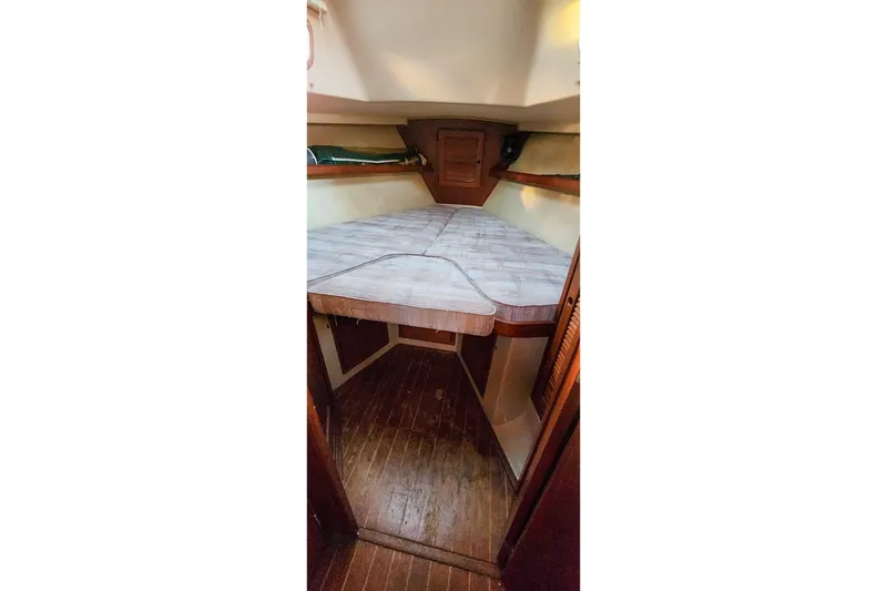 Slide: The Image of 1990 Island Packet 32 sailboat cabin interior with V-berth and wooden flooring. - 36