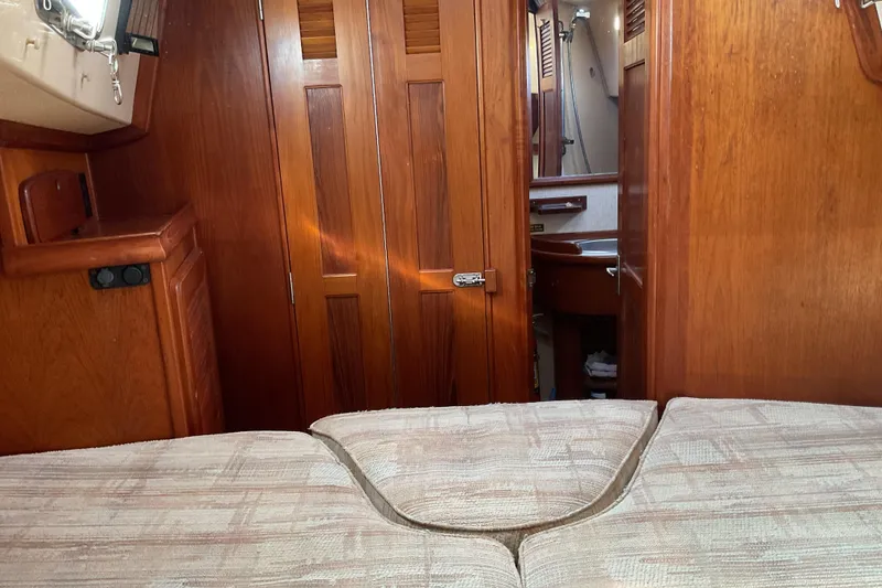 Slide: The Image of Interior of 1990 Island Packet 32 sailboat with wooden cabinetry and cozy sleeping area. - 37